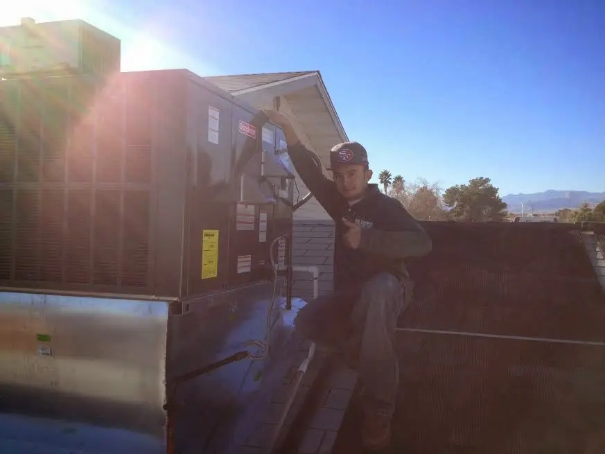 HVAC technician performing HVAC Inspection on a rooftop unit in Eden